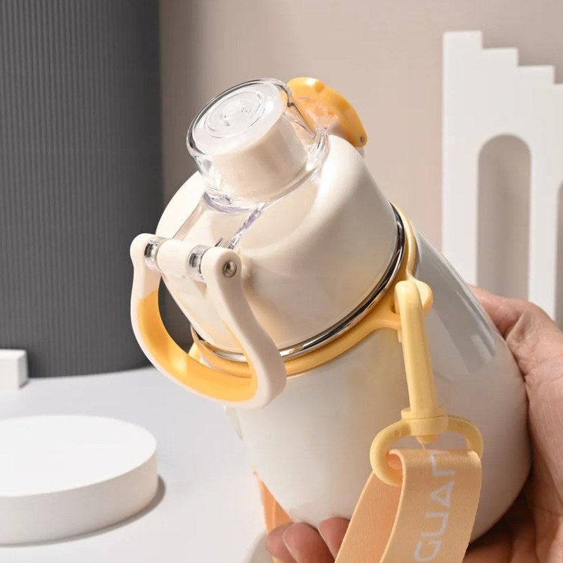 Gourde inox enfant blanche, tenue en main avec bandoulière